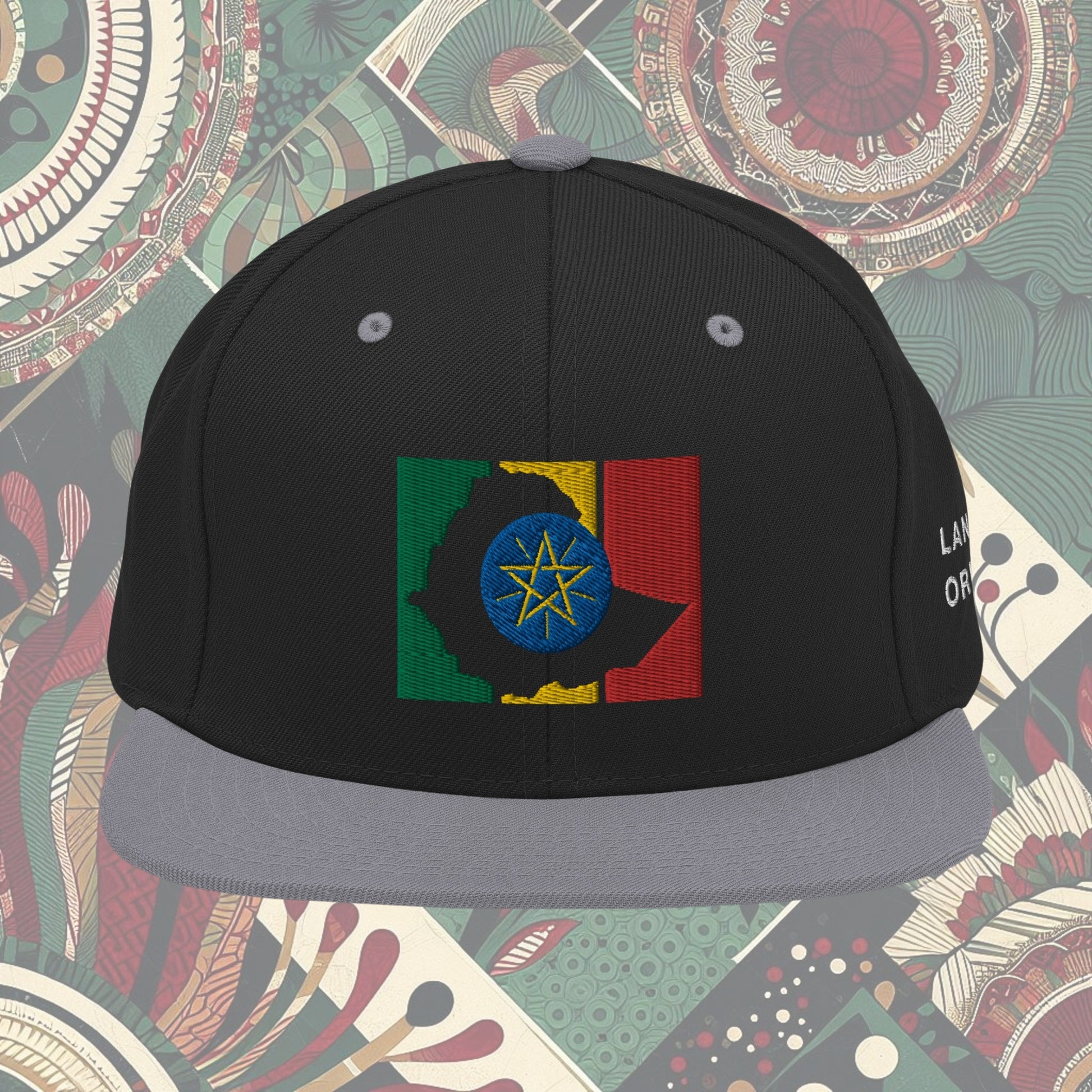 grey brim Ethiopia flag snapback from a Black-owned business with 'Land of Origin' on the side. Features vibrant flag colors. Perfect for showing national pride. Available now.