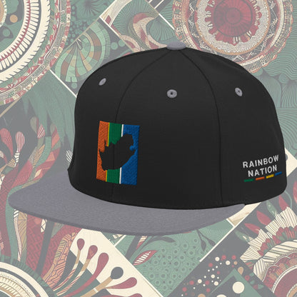 Grey brim South Africa flag snapback with 'Rainbow Nation' written on the side. Features vibrant flag colors and a statement celebrating South Africa's diversity. Ideal for showcasing pride and enhancing your style.